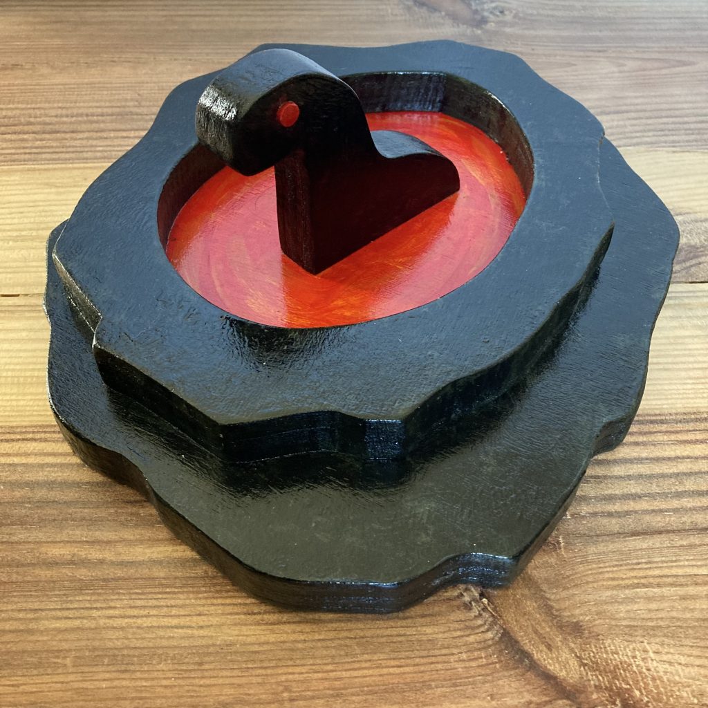 painted wooden sculpture of a creature sitting in a pool